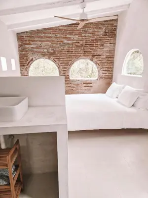 a bedroom with two beds and a brick wall at Casa Om in Dosríus