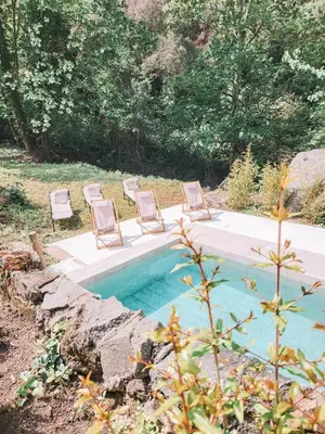 a group of chairs sitting next to a swimming pool at Casa Om in Dosríus