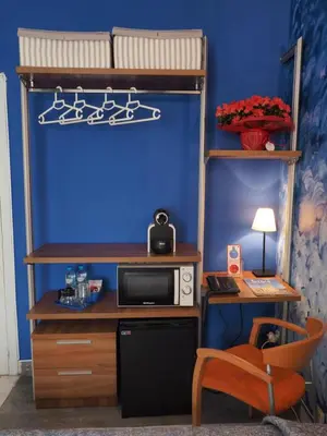 a bedroom with a bunk bed and a desk with a microwave at Hotel Montserrat in Sitges