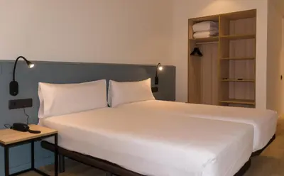 a room with a bed and a desk and a table at Hotel Sant Pau in Barcelona