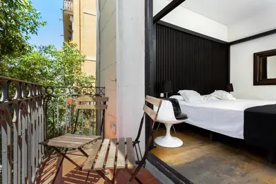 a bedroom on a balcony with a bed and a chair at Hotel Market in Barcelona