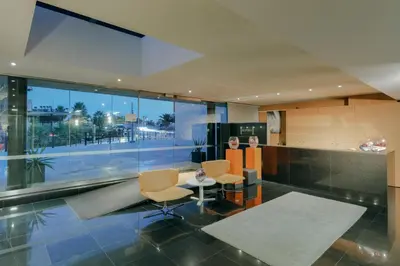 a lobby with a table and chairs in a building at Hesperia Fira in Hospitalet de Llobregat