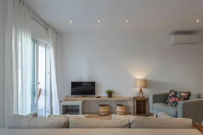 a living room with a couch and a television at Mare Nostrum: En el corazón de Sitges in Sitges