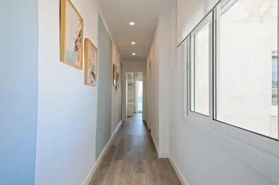 a hallway with white walls and a window at Alcam Badalona Roger in Badalona