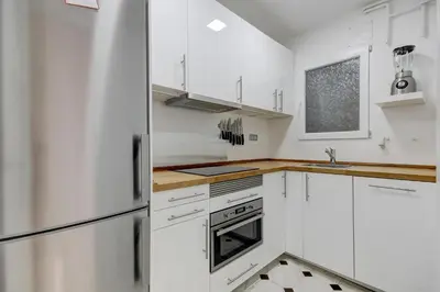 a kitchen with white cabinets and a refrigerator at Barcelona Beach Vibes in Sant Adria de Besos