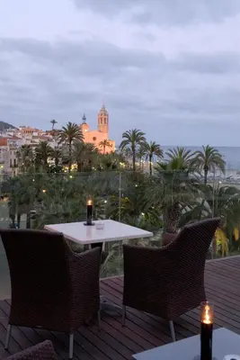 a table and chairs on a deck with a view of the city at Platjador in Sitges