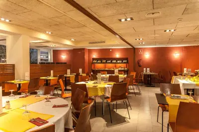 a dining room with tables and chairs with yellow napkins at Platjador in Sitges