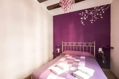 a purple bedroom with a bed with towels on it at Consell Cent apartment I 3 dormitorios Eixample in Barcelona