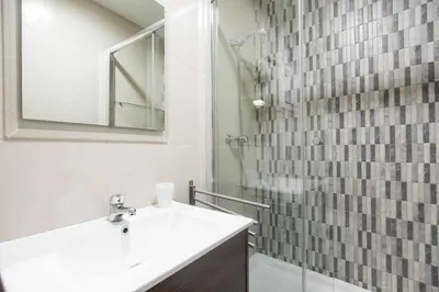 a bathroom with a sink and a shower with a mirror at Consell Cent apartment I 3 dormitorios Eixample in Barcelona