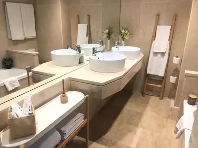 a bathroom with three sinks and a large mirror at Mediterraneo Sitges in Sitges