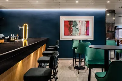 a bar with blue walls and green chairs at Hotel HC*** Mollet Barcelona in Mollet del Vallès