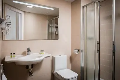 a bathroom with a sink and a toilet and a mirror at Hotel HC*** Mollet Barcelona in Mollet del Vallès