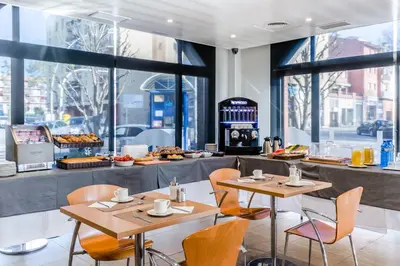 a restaurant with two tables and chairs and a bakery at Hotel HC*** Mollet Barcelona in Mollet del Vallès