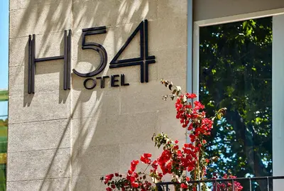 a sign on the side of a building with red flowers at Hotel 54 Barceloneta in Barcelona