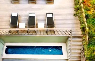 a building with chairs and a pool of water at Barcelona Apartment Aramunt in Barcelona