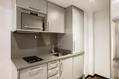 a kitchen with white cabinets and a sink at Barcelona Apartment Aramunt in Barcelona