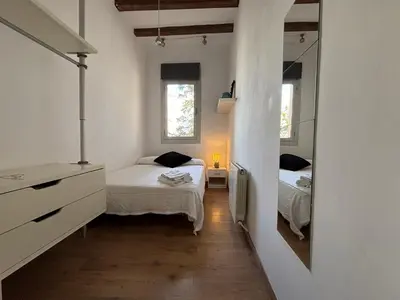 a small bedroom with two beds and a mirror at MODERN FLAT POBLE NOU in Barcelona