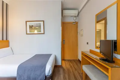 a hotel room with a bed and a television at Hotel Lyon in Barcelona