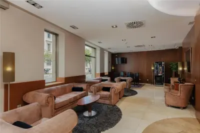 a waiting room with couches and tables in a building at Hotel Santa Marta in Barcelona