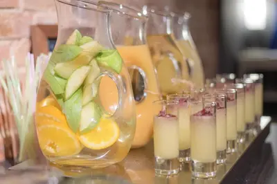 a row of glasses filled with fruit and orange juice at Petit Palace Museum in Barcelona