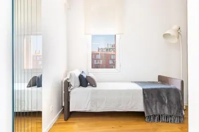 a white bedroom with a bed and a window at Idyllic apartment in BCN beach in Barcelona