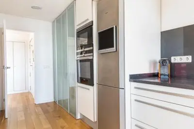 a kitchen with a stainless steel refrigerator and a glass wall at Idyllic apartment in BCN beach in Barcelona
