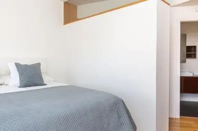 a white bedroom with a bed with a blue blanket at Idyllic apartment in BCN beach in Barcelona