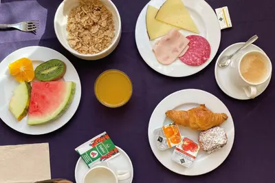 a table with plates of food and cups of coffee at Onix Liceo in Barcelona