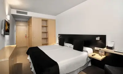 a hotel room with a large bed and a desk at Onix Liceo in Barcelona