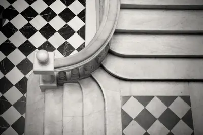 a mirror on the side of a door with a checkerboard floor at Onix Liceo in Barcelona