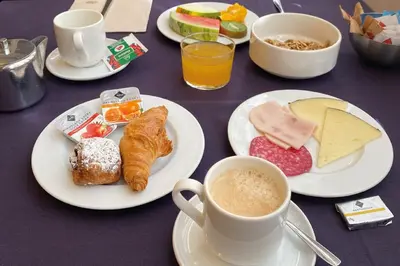 a table with plates of food and a cup of coffee at Onix Liceo in Barcelona