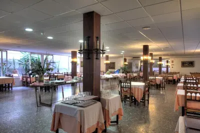 a dining room with tables and chairs in a restaurant at El Cid in Sitges