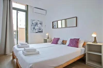 a white bedroom with a large bed with towels on it at Beautiful apartment in Las Ramblas Barcelona 6pax in Barcelona