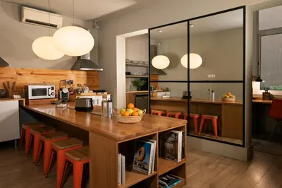 a kitchen with a large wooden table and orange chairs at Chic & Basic Tallers Hostal in Barcelona