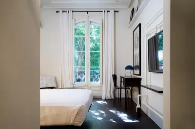 a bedroom with a bed and a window and a desk at Praktik Garden in Barcelona