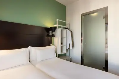 a bedroom with a white bed with a black headboard at Praktik Garden in Barcelona
