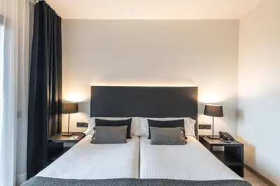 a bedroom with a large white bed with two lamps at Hotel Paseo de Gracia in Barcelona