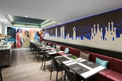 a row of tables in a restaurant with a mural at Catalonia Avinyo in Barcelona