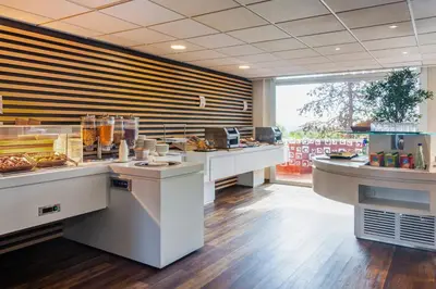 a restaurant with a counter with food on it at Checkin Montserrat in Collbató