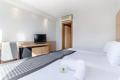 a white room with a bed and a desk at Exe Campus in Bellaterra