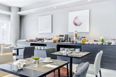 a restaurant with tables and chairs and a counter at Exe Campus in Bellaterra