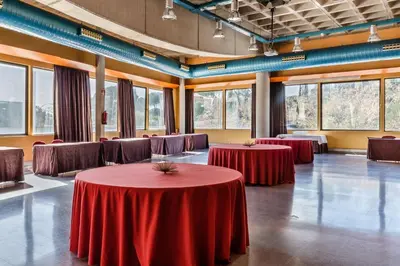 a room with red tables and chairs and windows at Exe Campus in Bellaterra
