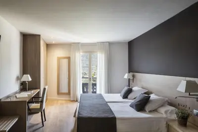 a hotel room with a bed and a desk and a desk at Balneari Termes Victòria in Caldes de Montbui