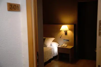 a bedroom with a bed and a lamp on a table at Balneari Termes Victòria in Caldes de Montbui