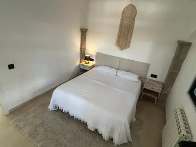 a white bedroom with a white bed and a lamp at Costa Maresme Barcelona , Relax & Pool in Cabrils