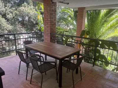 a wooden table and chairs on a balcony at Costa Maresme Barcelona , Relax & Pool in Cabrils