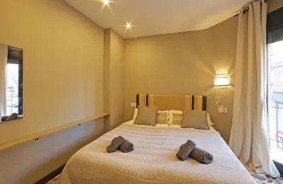 a bedroom with a bed with two pillows on it at Fridays Flats Onix House in Hospitalet de Llobregat