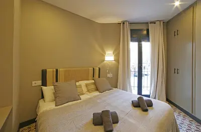 a bedroom with a large bed with two towels on it at Fridays Flats Onix House in Hospitalet de Llobregat