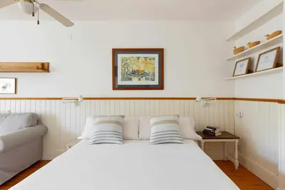 a bedroom with a white bed with two pillows at Central - a 10 minutos de la paya in Sitges