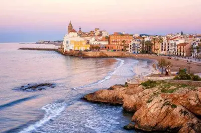 a view of a beach with buildings and the ocean at Central - a 10 minutos de la paya in Sitges